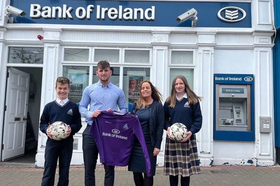 (second from left) Teacher Cormac Byrne receives the newly sponsored jerseys from Gillian Dunne, Bank of Ireland Customer Service Manage, with students Isaac Carcone and Faith Cassidy Canavan.