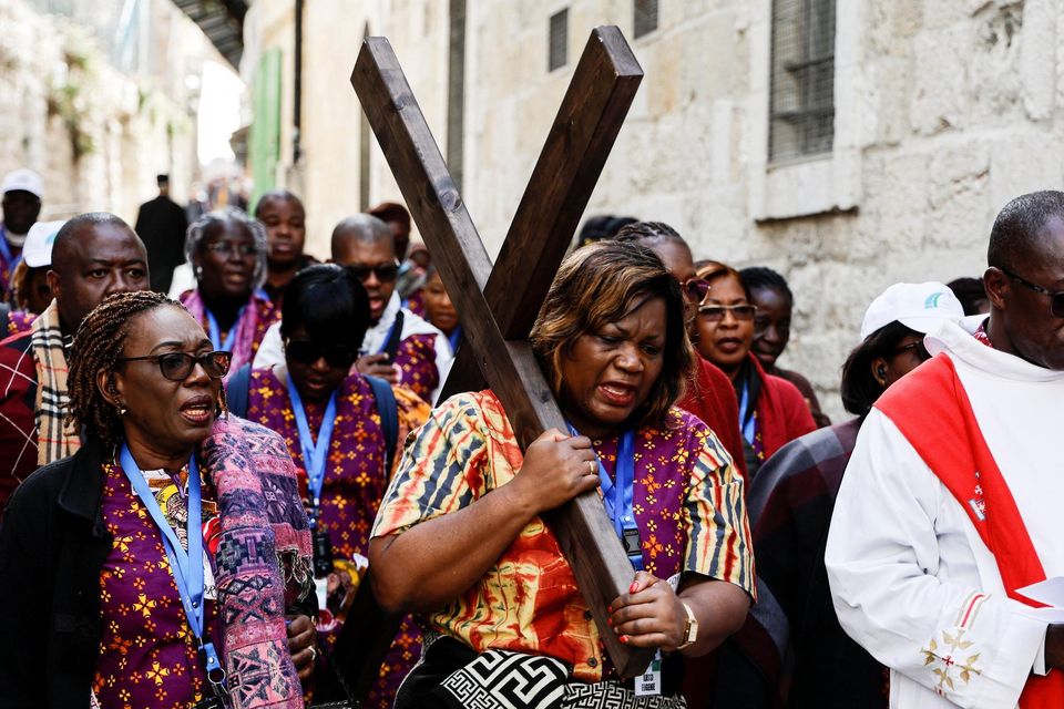 Worshippers carry a cross as they take part in the Good Friday procession at the Via Dolorosa in Jerusalem's Old City, April 7, 2023. REUTERS/Ammar Awad