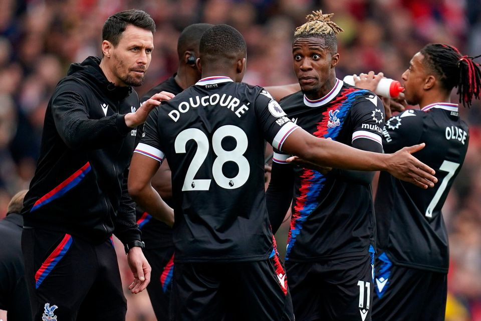 Crystal Palace interim manager Paddy McCarthy speaks to Cheick Doucoure and Wilfried Zaha on the touchline during their loss at Arsenal. Photo: PA