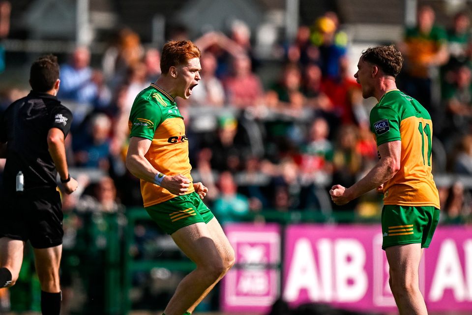 Ciaran Moore of Donegal, centre, celebrates with teammate Ciaran Thompson after kicking their side's winning point