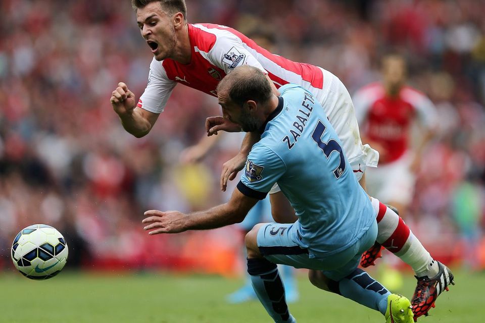 Arsenal's Aaron Ramsey (left) is tackled by Manchester City's Pablo Zabaleta during the Barclays Premier League match at the Emirates Stadium, London