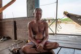 thumbnail: A former fisherman poses in his home at the floating village of Mechrey