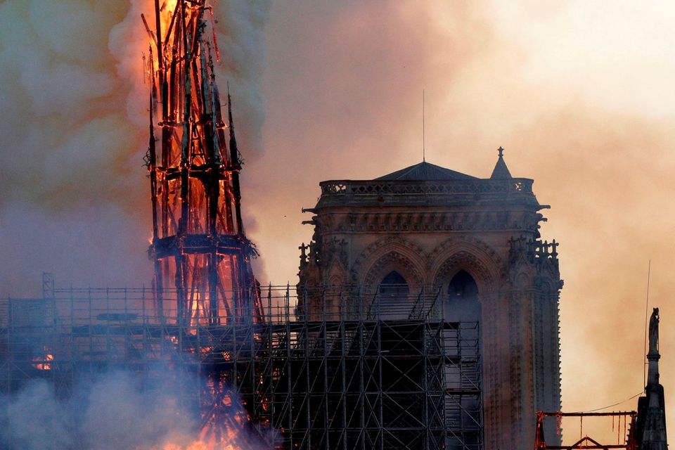 The steeple of the landmark Notre-Dame Cathedral collapses as the cathedral is engulfed in flames in central Paris on April 15, 2019.