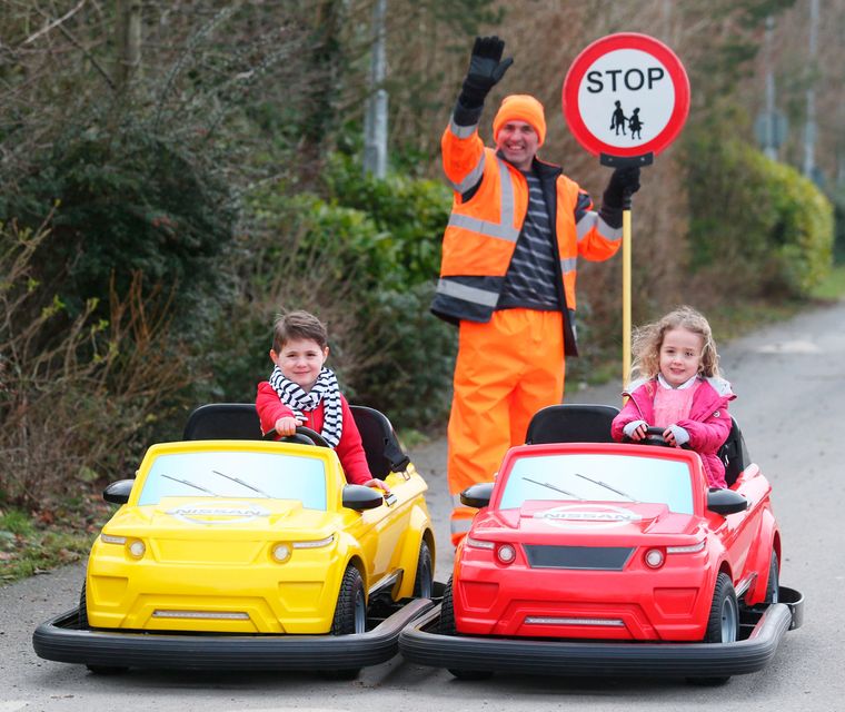 Local lollipop man, David Mitchell from St. Andrews National School, Asbourne, Co.Meath with Twins Conor and Tara Ocks - the first children to try out the cars featured at the Nissan Driving School at Tayto Park, when it launched this year. Photo: Leon Farrell/Photocall Ireland.