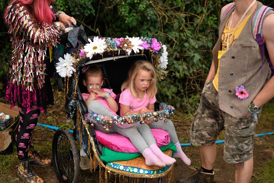 Two young revellers sit in a pram at the Glastonbury Festival of Music and Performing Arts on Worthy Farm near the village of Pilton in Somerset, South West England, on June 26, 2019. (Photo by Oli SCARFF / AFP)OLI SCARFF/AFP/Getty Images