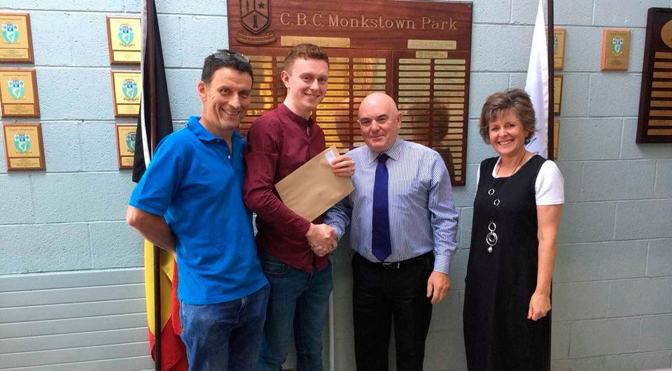 Alan Hickey receives his Leaving Cert results from his principal Gerry Berry, alongside his proud parents Dara and Siobhan
