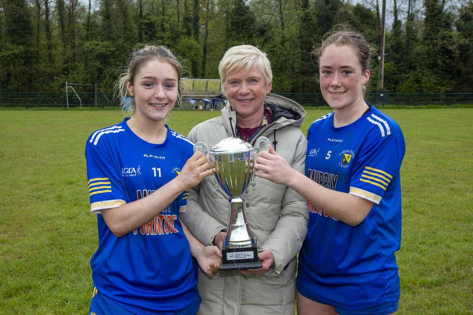 Coláiste Bhríde Principal Linda Dunne presents the Wicklow Schools Senior 'A' football cup to Coláiste Bhríde captains Yasmin Dagge and Laci-Jane Shannon after their win over St. Mary's College.  