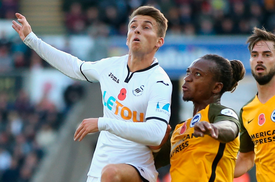 Tom Carroll of Swansea City and Gaetan Bong of Brighton and Hove Albion battle for the ball. Photo: Getty Images