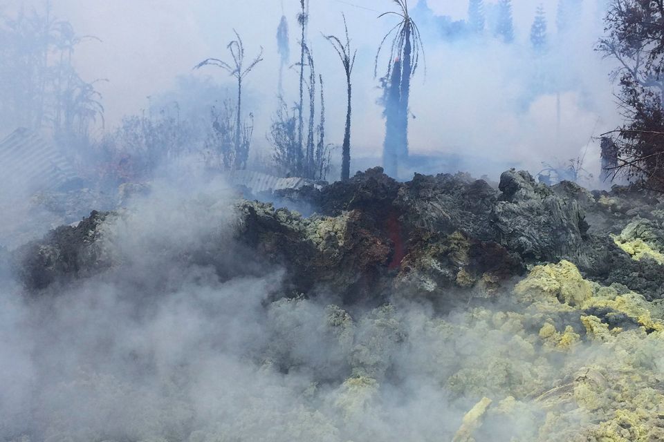 This Tuesday, May 15, 2018 photo provided by the U.S. Geological Survey shows incandescence observed at Fissure 14 around 10:30 a.m. HST at Kilauea Volcano, in Hawaii. Pulsing, gas-rushing sounds could be heard coming from the crack. Yellow sulfur deposits appear on the crack margins. (U.S. Geological Survey/HVO via AP)