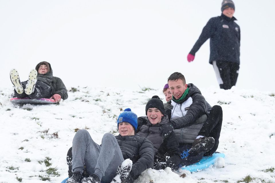 Teenagers having fun on sleds and bodyboards in the snow at Lissycasey, Co Clare, on Thursday. Photo: Eamon Ward