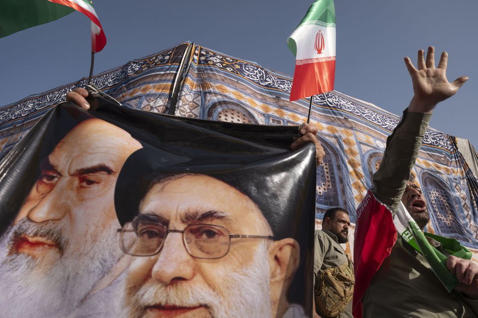 An Iranian protester shouts anti-US and anti-Israeli slogans while standing next to the portraits of Iran’s supreme leader Ayatollah Ali Khamenei and former leader Ruhollah Khomeini during a protest in Tehran. Photo: Getty
