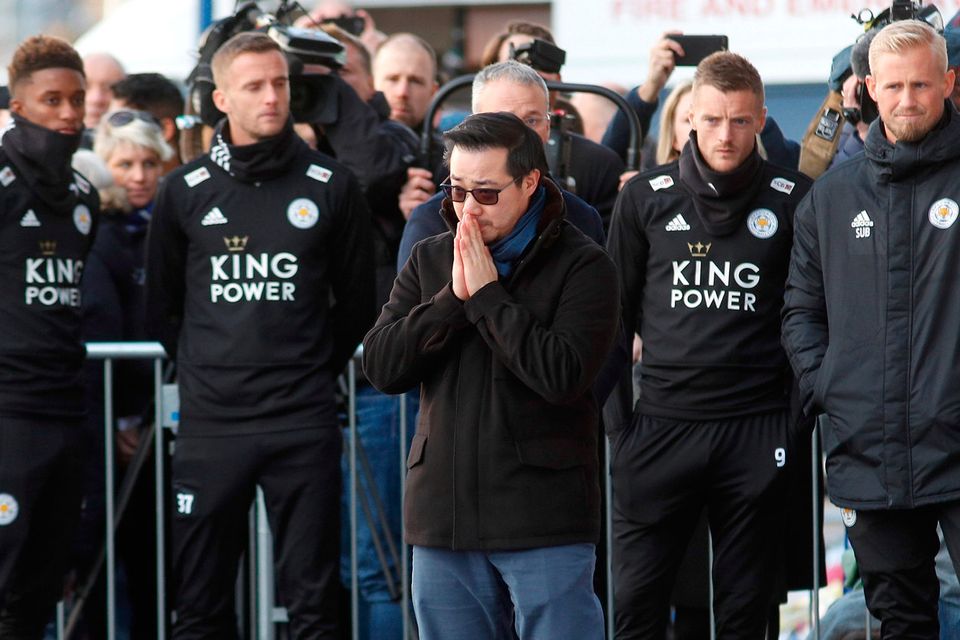 Khun Aiyawatt Srivaddhanaprabha, son of Leicester City's owner Thai businessman Vichai Srivaddhanaprabha, clasps his hands together as he stands infront of Jamie Vardy and Kasper Schmeichel amongst tributes left for Vichai and four other people who died when the helicopter they were travelling in crashed as it left the ground after the match on Saturday, in Leicester, Britain, October 29, 2018. REUTERS/Peter Nicholls