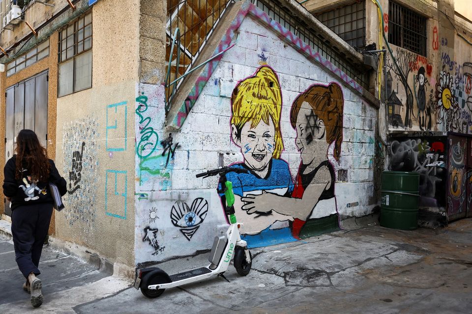 A person walks past graffiti on a wall in Tel Aviv yesterday. Photo: Reuters