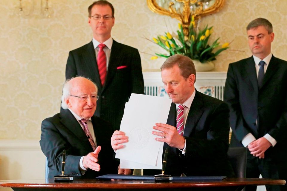 General to the President Art O'Leary (back left) and Secretary General at the Department of the Taoiseach, Martin Fraser (back right) watch as Taoiseach Enda Kenny (right) and President Michael D Higgins sign an order dissolving the Irish Parliament and starting the 2016 general election campaign at Aras an Uachtarain. Photo: Niall Carson/PA Wire