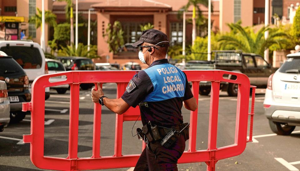 Top: A policeman blocks access to the hotel in Tenerife. Photo: AP