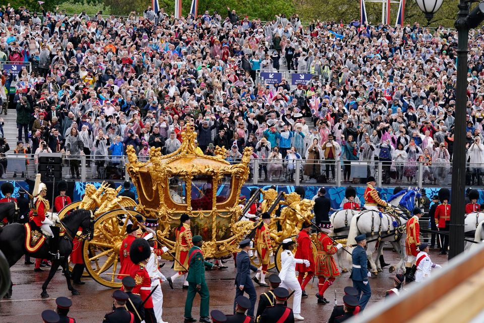 King Charles III and Queen Camilla are carried in the Gold State Coach, pulled by eight Windsor Greys, in The Coronation Procession as they return along The Mall to Buckingham Palace, London, following their coronation ceremony.  Photo: Niall Carson/PA Wire