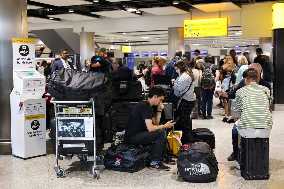 Travellers wait near the British Airways check-in area at Heathrow Airport, as Britain's National Air Traffic Service (NATS) restricts UK air traffic due to a technical issue causing delays, in London, Britain, August 28, 2023. REUTERS/Hollie Adams/File Photo