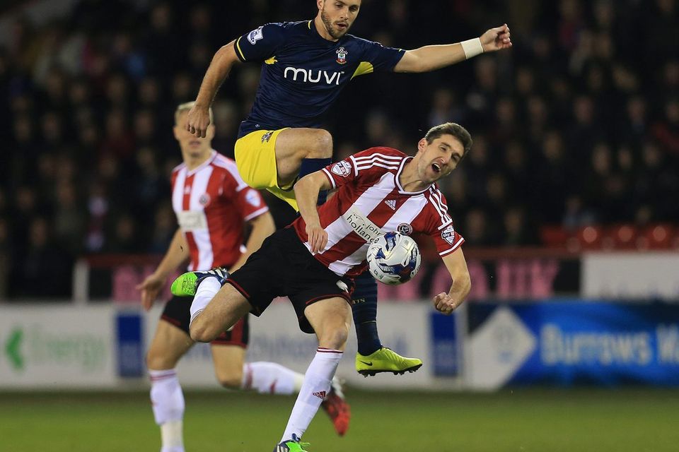 Southampton's Shane Long collides with Chris Basham of Sheffield United during their Capital One Cup quarter-final clash at Bramall Lane. Photo: Lynne Cameron/PA Wire