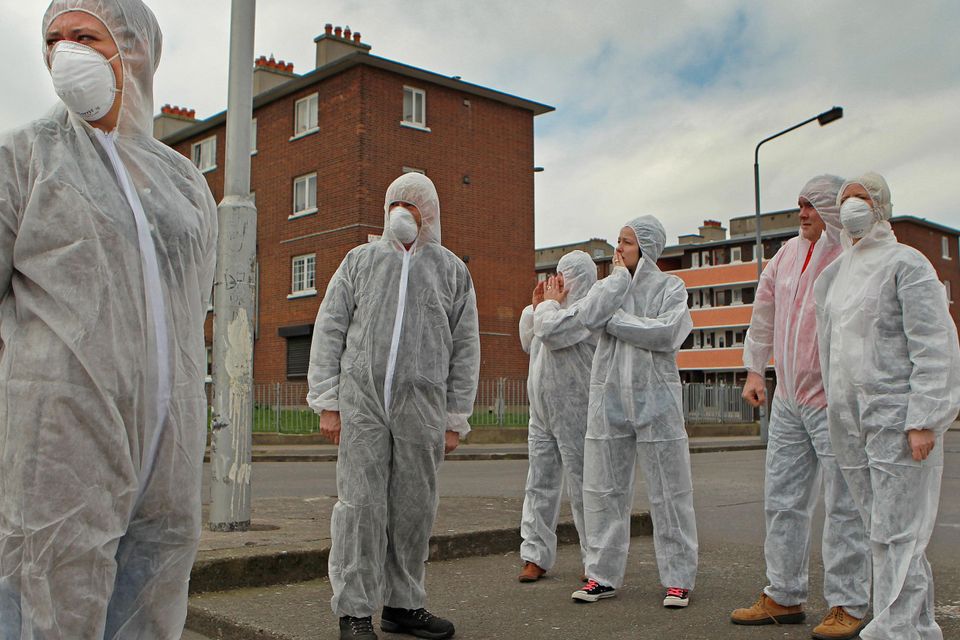 Residents of Dolphin House protest dressed in biohazard suits to illustrate problems with damp and sewerage