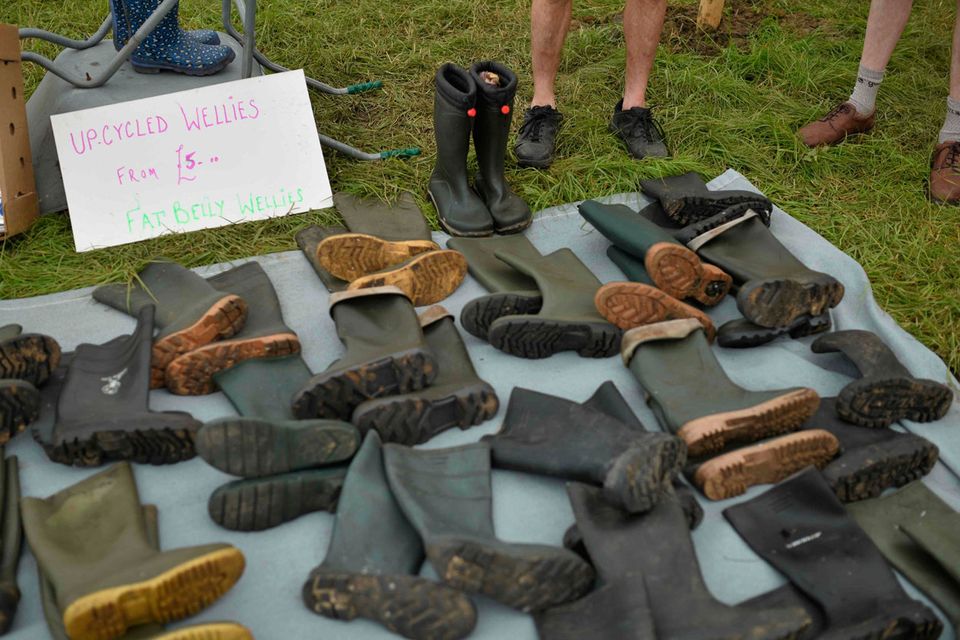 A stall tender shows his 'upcycled' Wellington boots for sale at the Glastonbury Festival of Music and Performing Arts on Worthy Farm near the village of Pilton in Somerset, South West England, on June 26, 2019. (Photo by Oli SCARFF / AFP)OLI SCARFF/AFP/Getty Images