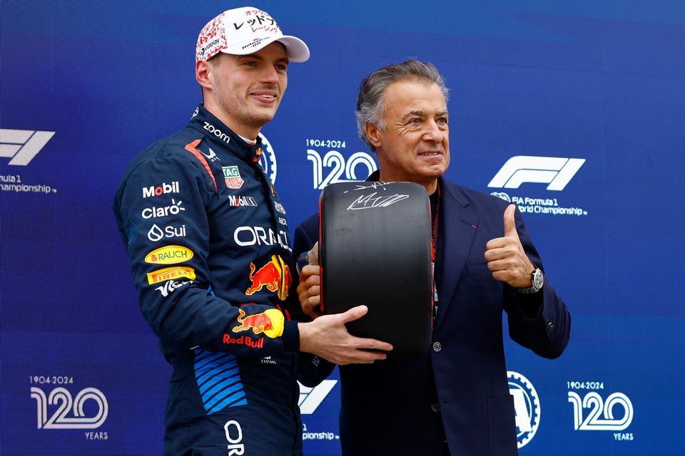 Red Bull's Max Verstappen poses with an award from former F1 driver Jean Alesi after qualifying in pole position at the Japanese Grand Prix in Suzuka, Japan