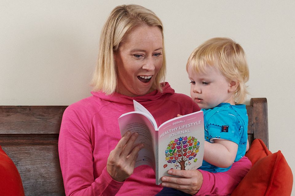 Olympian Derval O’Rourke leafs through her new healthy eating journal with her son Archie