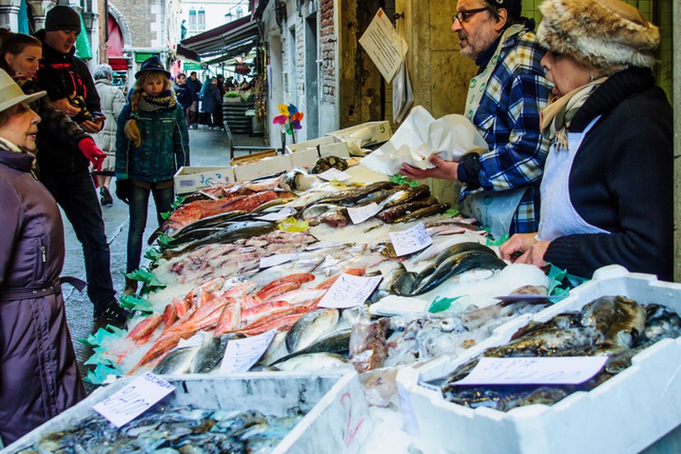 Sellers and shoppers in the Rialto market, in Venice,