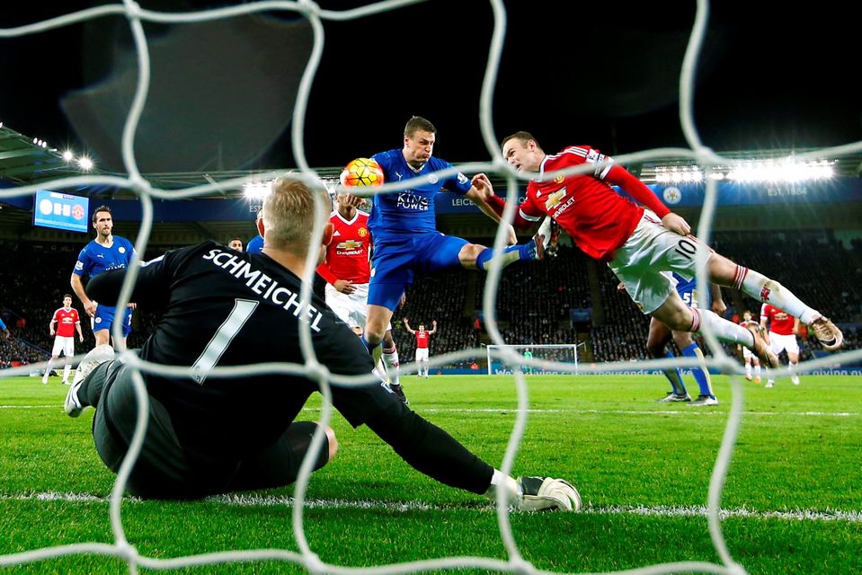 Manchester United's Wayne Rooney and Leicester's Robert Huth in action as Kasper Schmeichel looks on