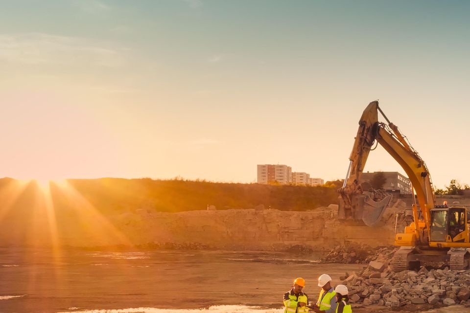 Aerial Drone Shot Of Construction Site With Excavators On Sunny Day: Diverse Team of Real Estate Developers Discussing Project. Civil Engineer, Architect, Inspector Talking And Using Tablet Computer.