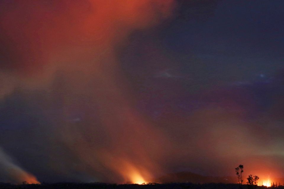 Lava shoots into the night sky from active fissures on the lower east rift of the Kilauea volcano, Tuesday, May 15, 2018 near Pahoa, Hawaii. (AP Photo/Caleb Jones)