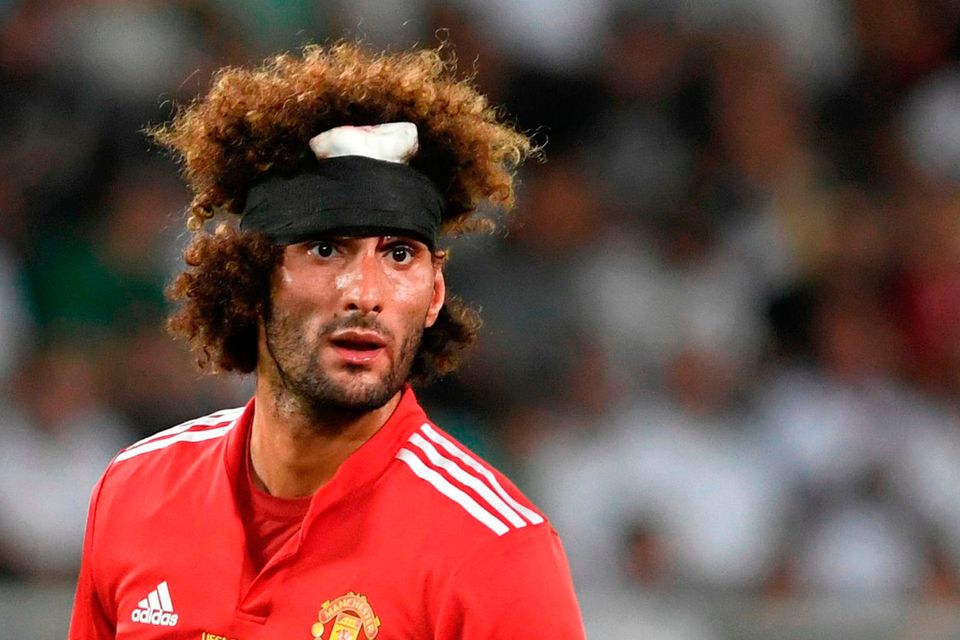 Manchester United's Belgian midfielder Marouane Fellaini already created some interesting images with a head band on his distinctive hair during Tuesday night's Super Cup clash with Real Madrid. / AFP PHOTO / Nikolay DOYCHINOVNIKOLAY DOYCHINOV/AFP/Getty Images