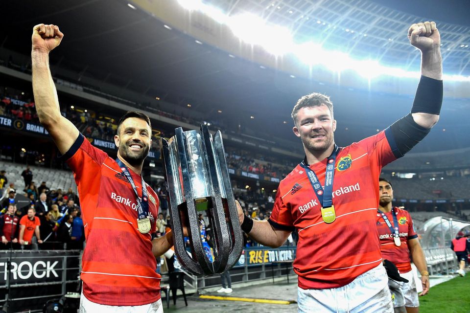 Conor Murray and Peter O'Mahony celebrate with the URC trophy.