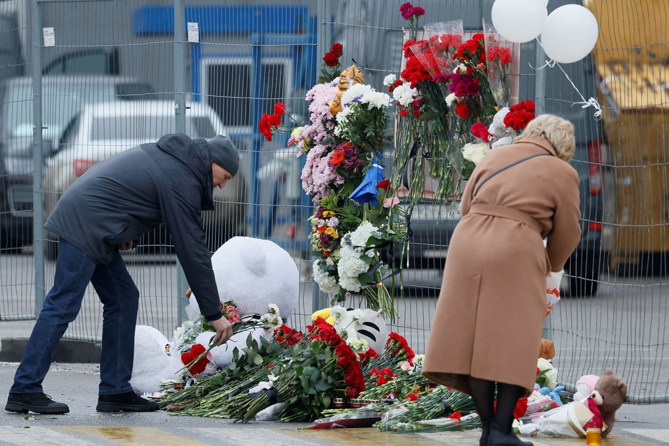 People lay flowers at a makeshift memorial to the victims of a shooting attack at the Crocus City Hall concert venue in Moscow, Russia