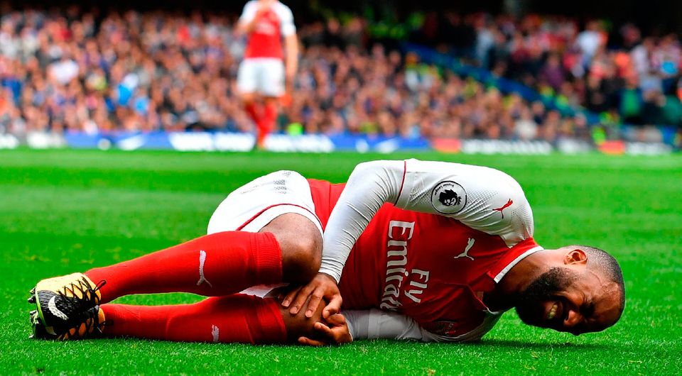Arsenal's French striker Alexandre Lacazette lies injured after a collision with Chelsea's Nigerian midfielder Victor Moses. Photo: Getty Images