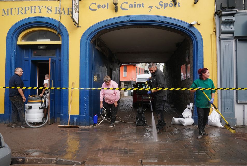 The clean up gets underway on Main Street in Midleton, Co Cork, after extensive damage caused by flooding following Storm Babet (PA)