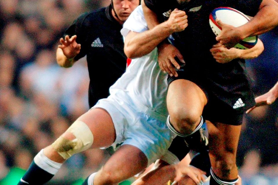 New Zealand All Blacks winger Jonah Lomu is held up for a moment before