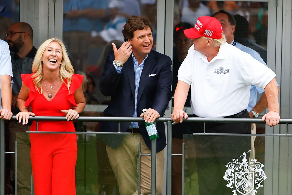 Marjorie Taylor Greene, Tucker Carlson and Donald Trump at a LIV golf event. Photo: Getty