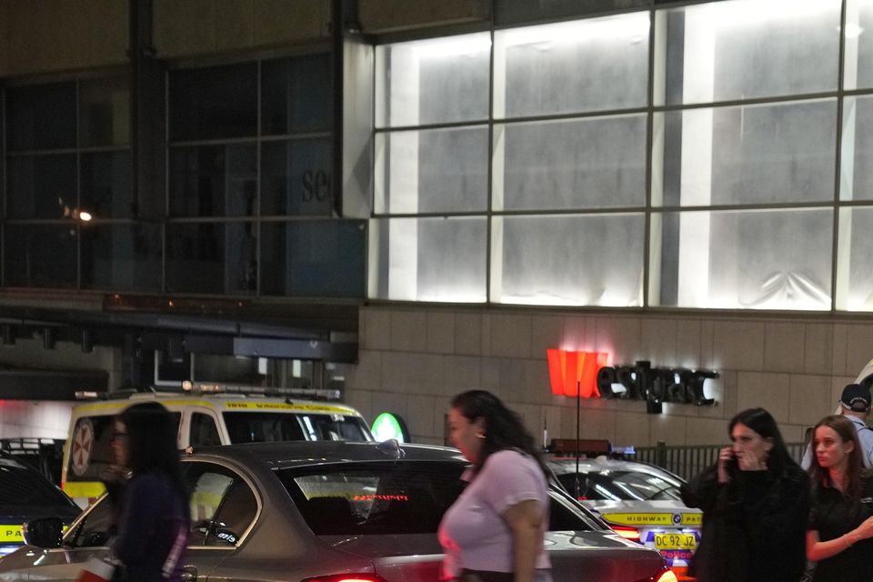 People are led out from the Westfield Shopping Centre where multiple people were stabbed (Rick Rycroft/AP)