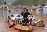 thumbnail: A family carry  their belongings along the Huatanay river in Cuzco, Peru (AP)