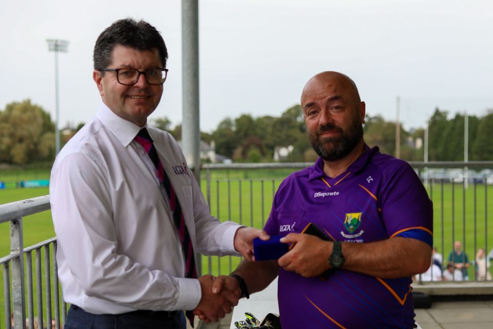 Wicklow LGFA Chairperson Stephen McNulty presents match referee Terry Canavan with a medal after the Junior final. 