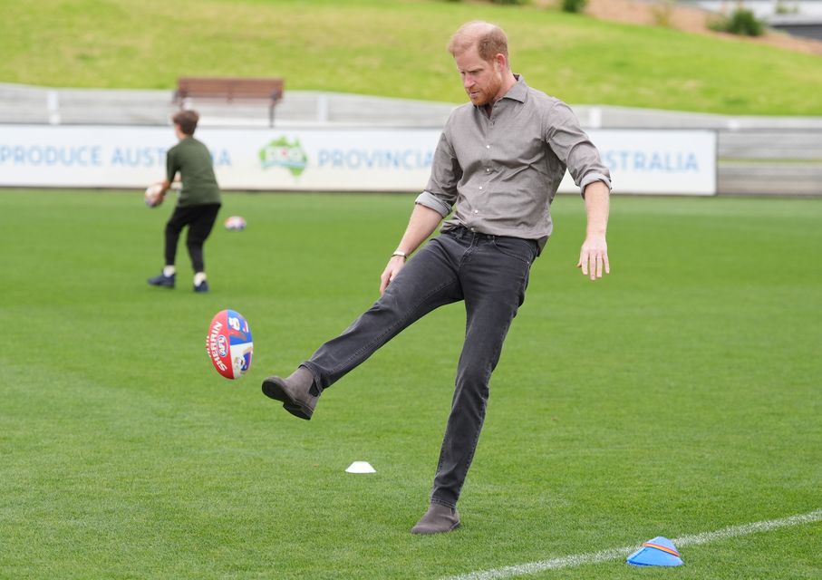 Harry kicked an Australian rules football as he met with Western Bulldogs players (Jonathan Brady/PA)