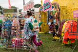 thumbnail: A reveller looks at merchandise displayed for sale at the Glastonbury Festival of Music and Performing Arts on Worthy Farm near the village of Pilton in Somerset, South West England, on June 26, 2019. (Photo by Oli SCARFF / AFP)OLI SCARFF/AFP/Getty Images