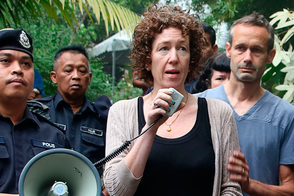 This handout from the Royal Malaysia Police taken and released on August 10, 2019 shows Meabh (C) and Sebastien (R), the parents of missing 15-year-old Franco-Irish teenager Nora Quoirin, standing with the police as they continue to search for her in Seremban.
