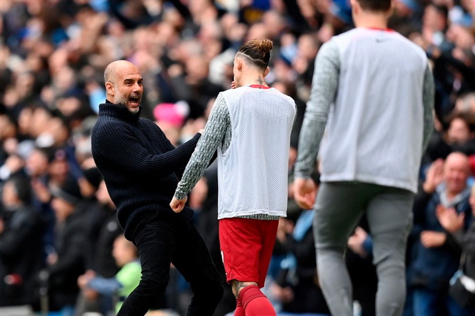 Pep Guardiola celebrates after his side's first goal in front of Liverpool players