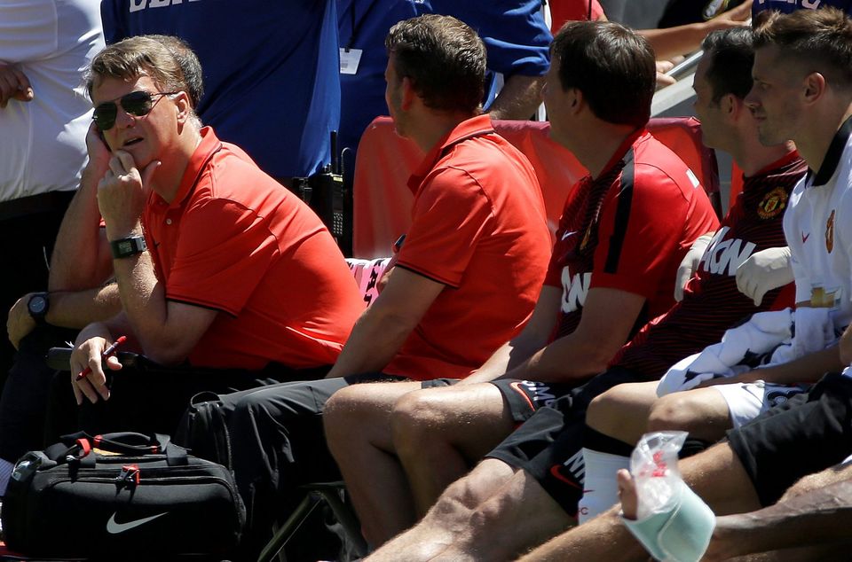 Manchester United manager Louis van Gaal, left, sits on the bench as he watches during the second half of an International Champions Cup soccer match against FC Barcelona in Santa Clara, Calif., Saturday, July 25, 2015. Manchester United won 3-1. (AP Photo/Jeff Chiu)