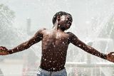 thumbnail: Jules Ruvoyivoyi, 13, dances in the water spray from a water hydrant powered fountain during a library water block party