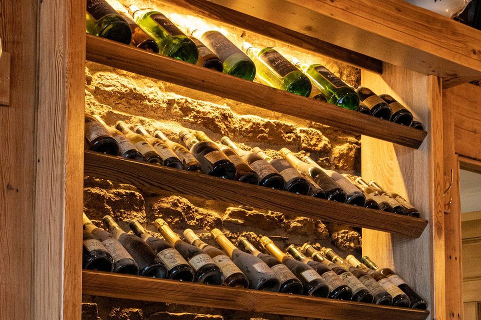 A feature wall created by aged bottles of wine found in the attic.