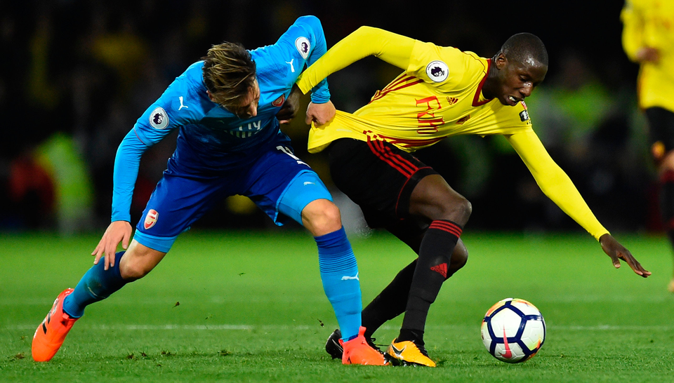 Arsenal's German midfielder Mesut Ozil (L) challenges Watford's French midfielder Abdoulaye Doucoure (R). Photo: Getty Images