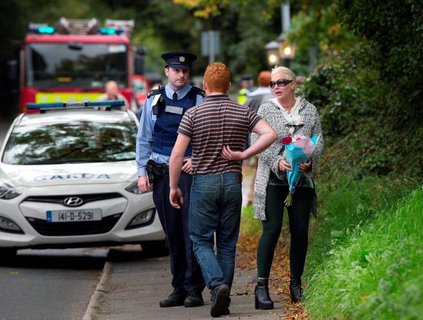 A well wisher brings flowers at the scene of the tragic fire at Glenamuck Road, Carrickmines, this morning. Photo: Tony Gavin.