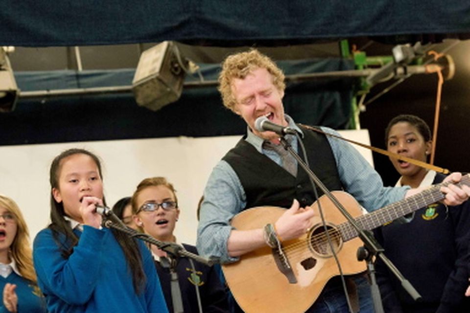 13/09/2013. Pictured is Oscar winner and renowned musician Glen Hansard performing 'Falling Slowly' with the choir at St Tiernan's Community School, Dundrum raising the school's first Green Flag from An Taisce. Photo: El Keegan